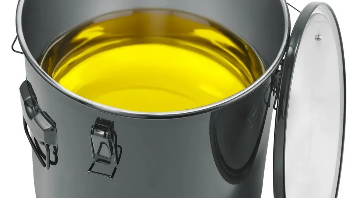 Fryer grease bucket filled with oil with the lid open
