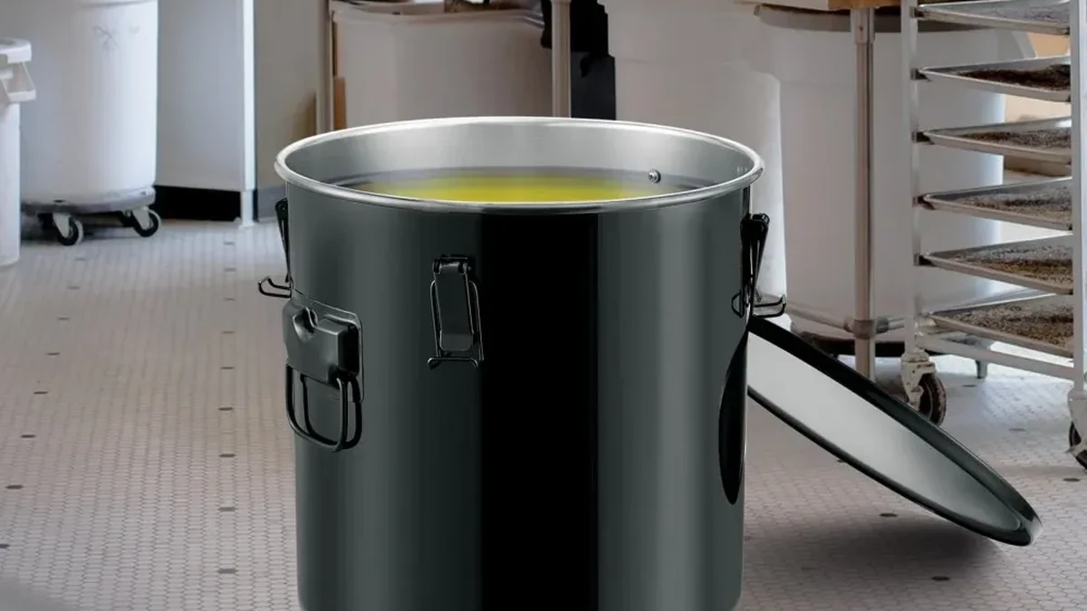 Stainless steel fryer grease bucket in a commercial kitchen