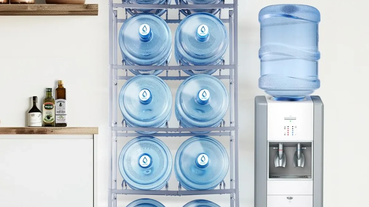 Water bottle storage rack next to a water cooler in a kitchen